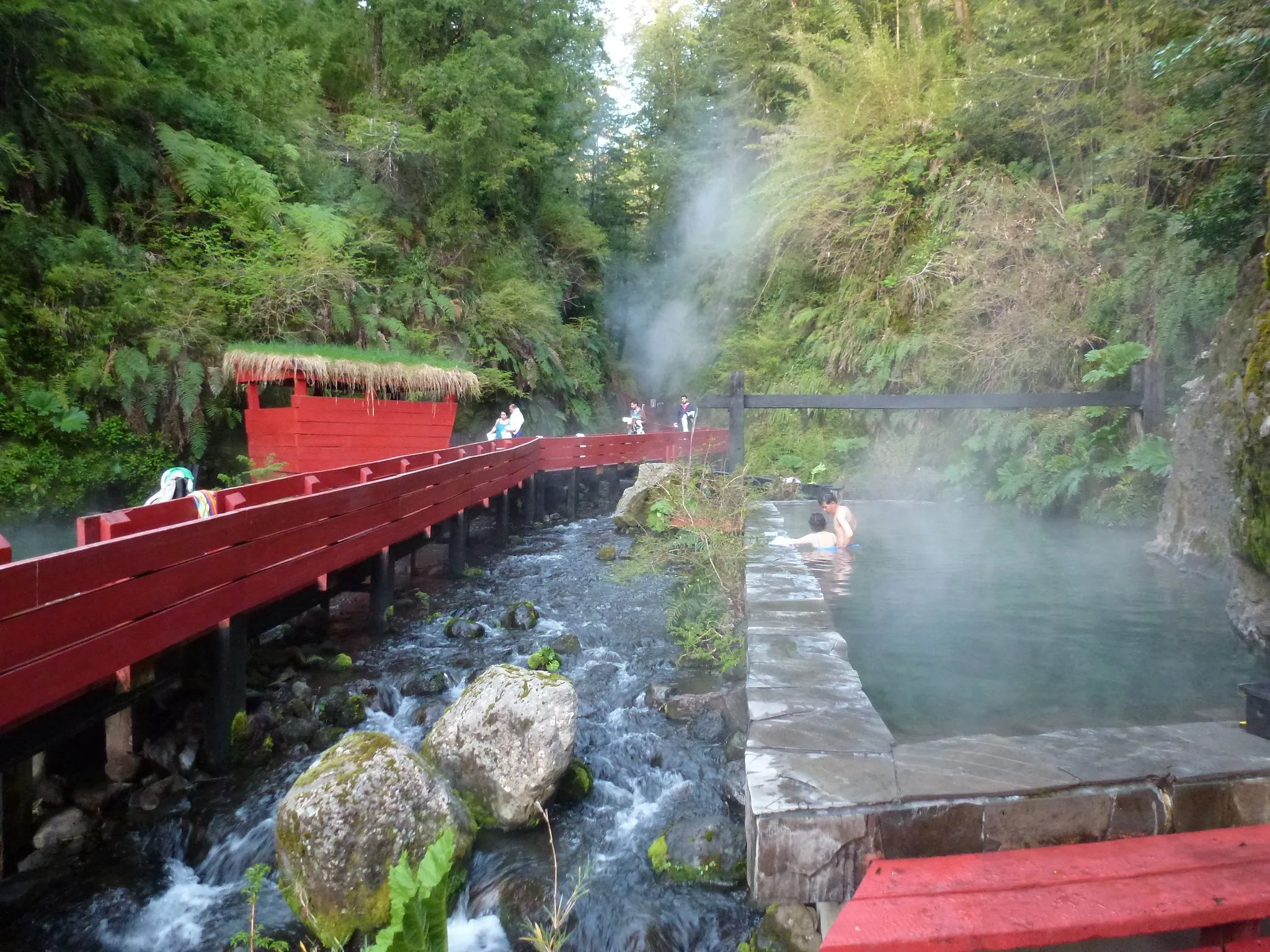 Pasarelas rojas y pozones con vapor termal en la quebrada de Termas Geométricas
